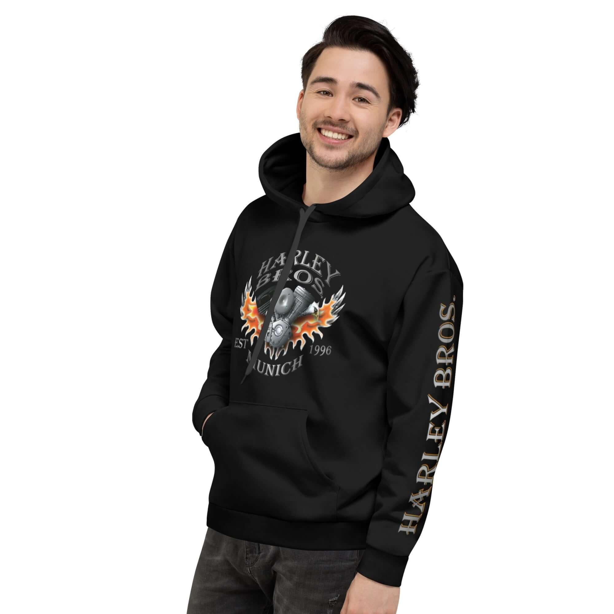 Lächelnder Mann in schwarzem Hoodie mit Harley Bros München Flammen-Print auf weißem Hintergrund