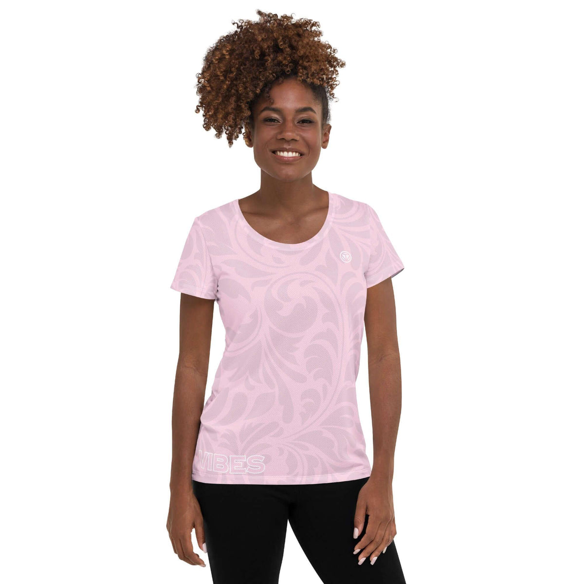 Frau in einem hellrosa T-Shirt mit weißem floralem Muster und VIBES-Schriftzug