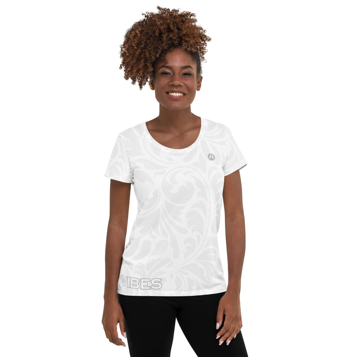 Frau mit lockigem Haar trägt ein weißes T-Shirt mit floralem Muster und VIBES-Print.