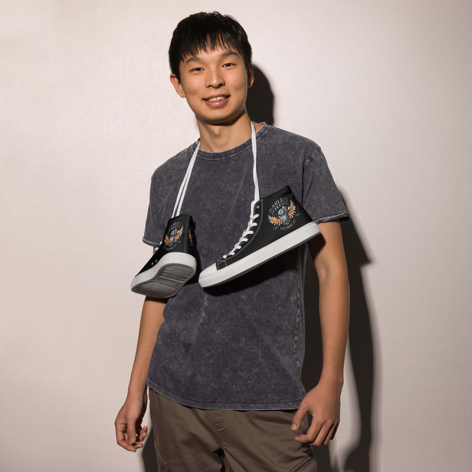 Junger Mann mit schwarzen High-Top-Sneakern und grafischem Muster, lässiger Look, Mode