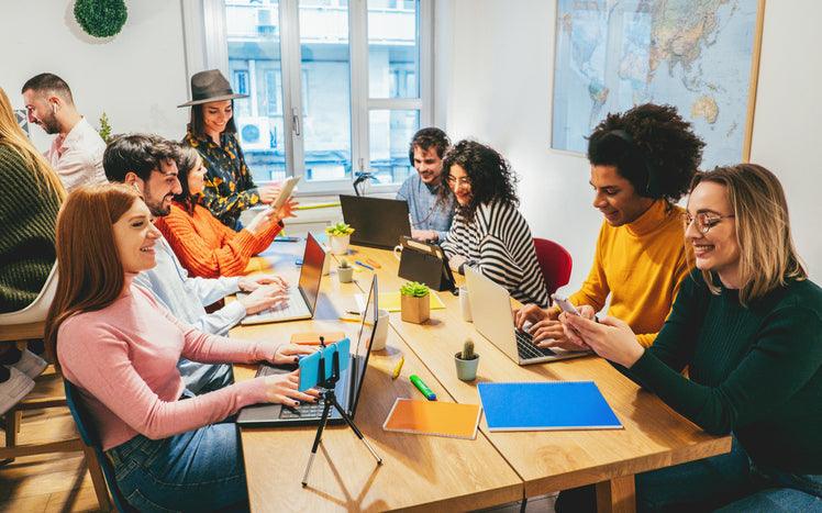 Junge Leute arbeiten im modernen Büro, gemeinsames Coworking mit Laptops und Tablets