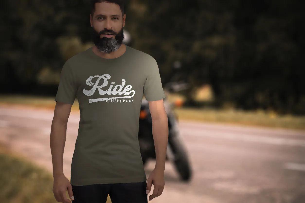 Mann mit Barth trägt T-Shirt mit 'Ride' Aufdruck, Straße und Motorrad im Hintergrund