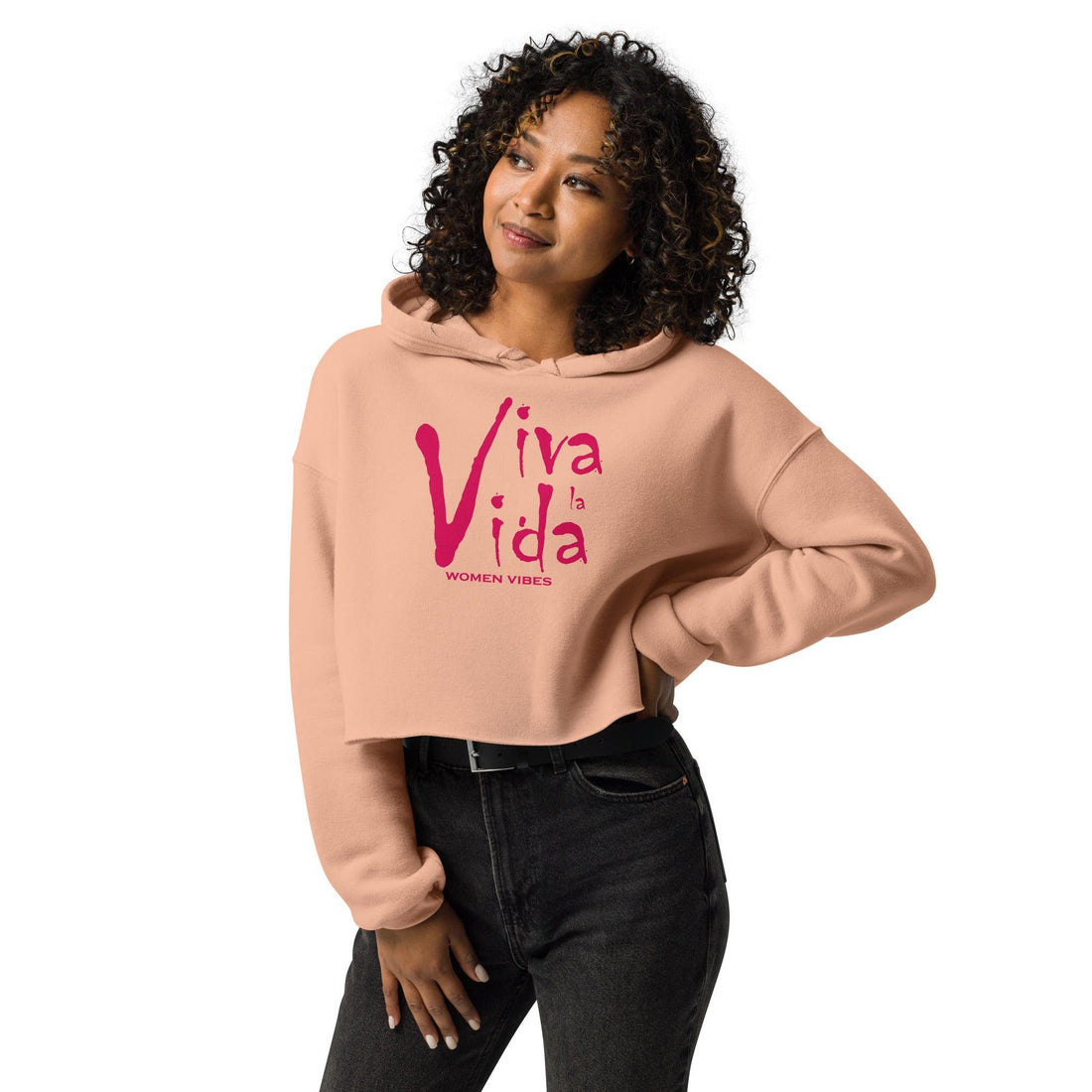 Frau trägt rosa Crop-Hoodie mit Viva la Vida Aufdruck und schwarzer Hose, Studioaufnahme