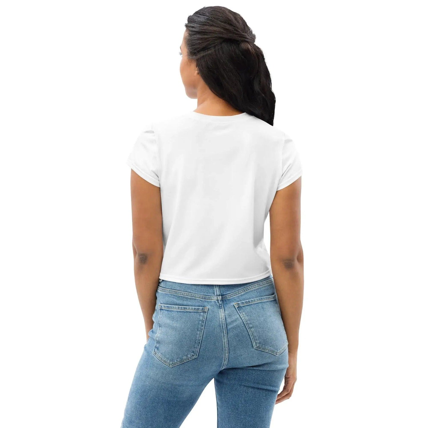 Frau von hinten mit weißem Crop-Top-Shirt und Jeans vor weißem Hintergrund