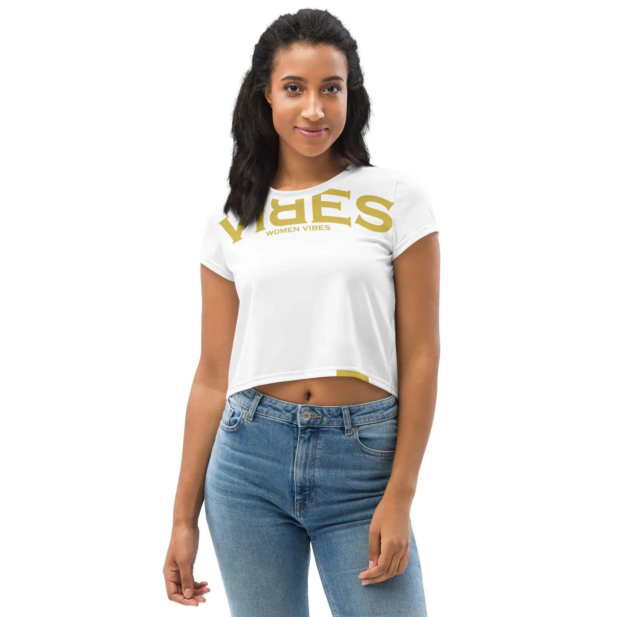 Junge Frau trägt weißes Crop-Top Shirt mit goldener Vibes-Aufschrift und blauer Jeans.