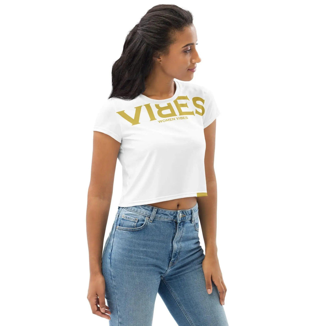 Frau im weißen VIBES Crop-Top Shirt mit goldener Aufschrift und blauer Jeans vor weißem Hintergrund