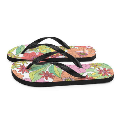Bunte Flip-Flops mit geblümtem Muster und schwarzen Riemen auf weißem Hintergrund