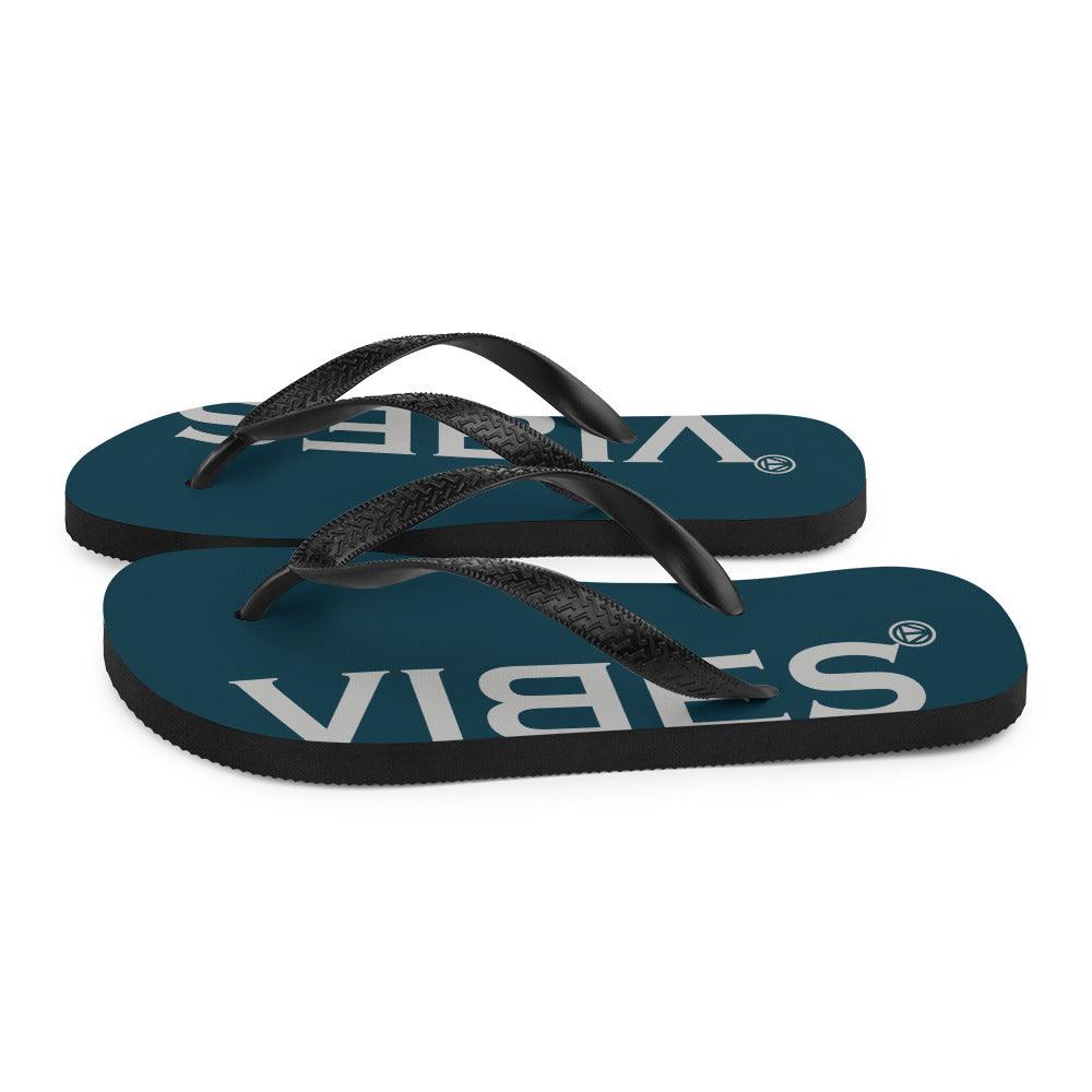Blaue VIBES Flip-Flops mit schwarzen Riemen auf weißem Hintergrund, modisches Sommerschuhwerk