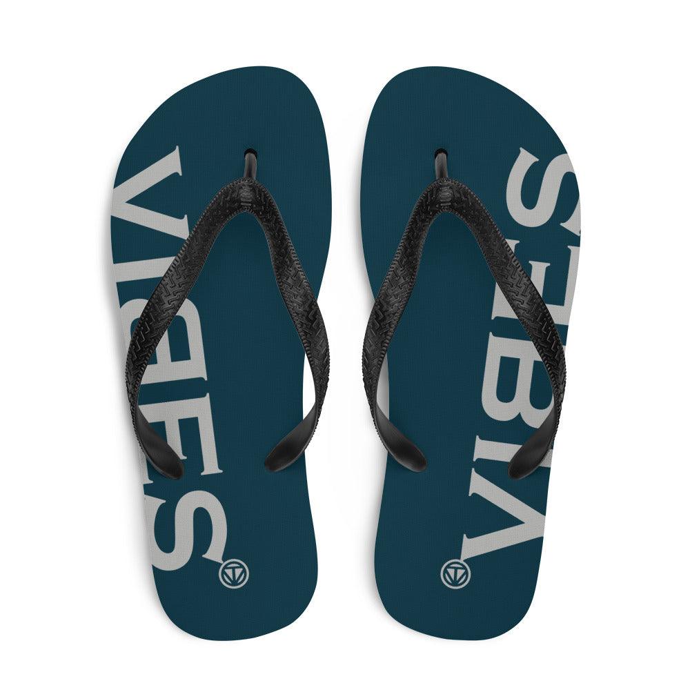 Blaue Flip-Flops mit schwarzem Riemen und weißem VIBES-Logo auf dem Fußbett