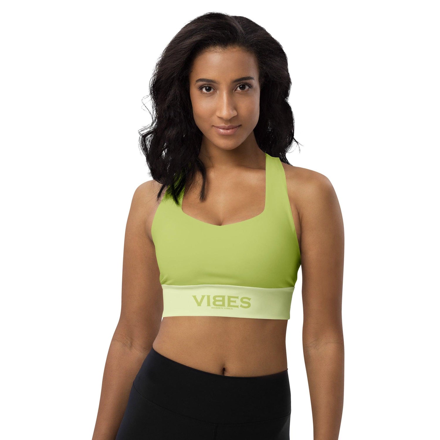 Frau trägt langen grünen Sport-BH VIBES, weiße Studiohintergrund, Fitnessmode