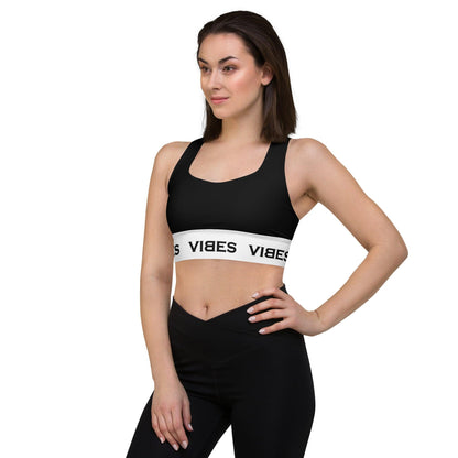Frau trägt schwarzen Sport-BH mit weißem VIBES-Band, Sportmode vor weißem Hintergrund