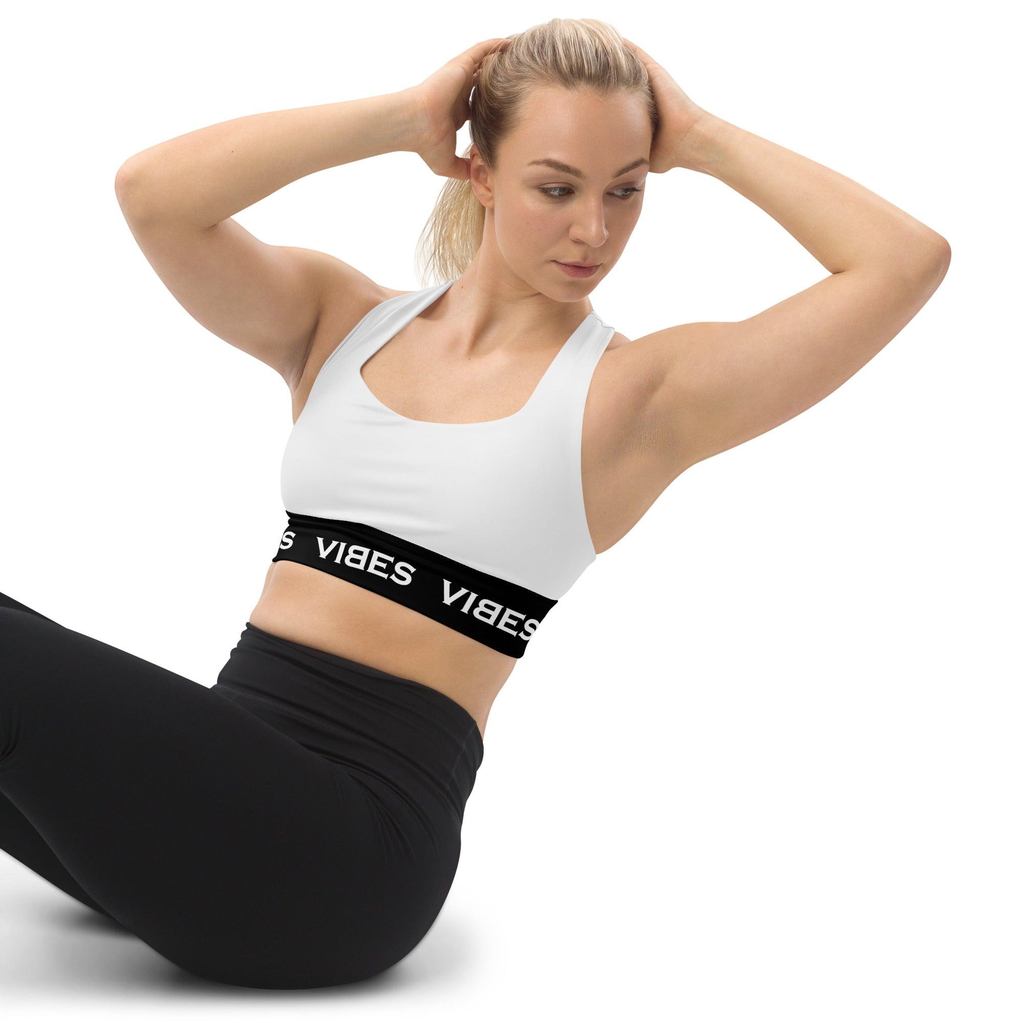 Frau beim Training trägt weißen VIBES Sport-BH mit schwarzem Band, Fitnessmode, Yoga Outfit