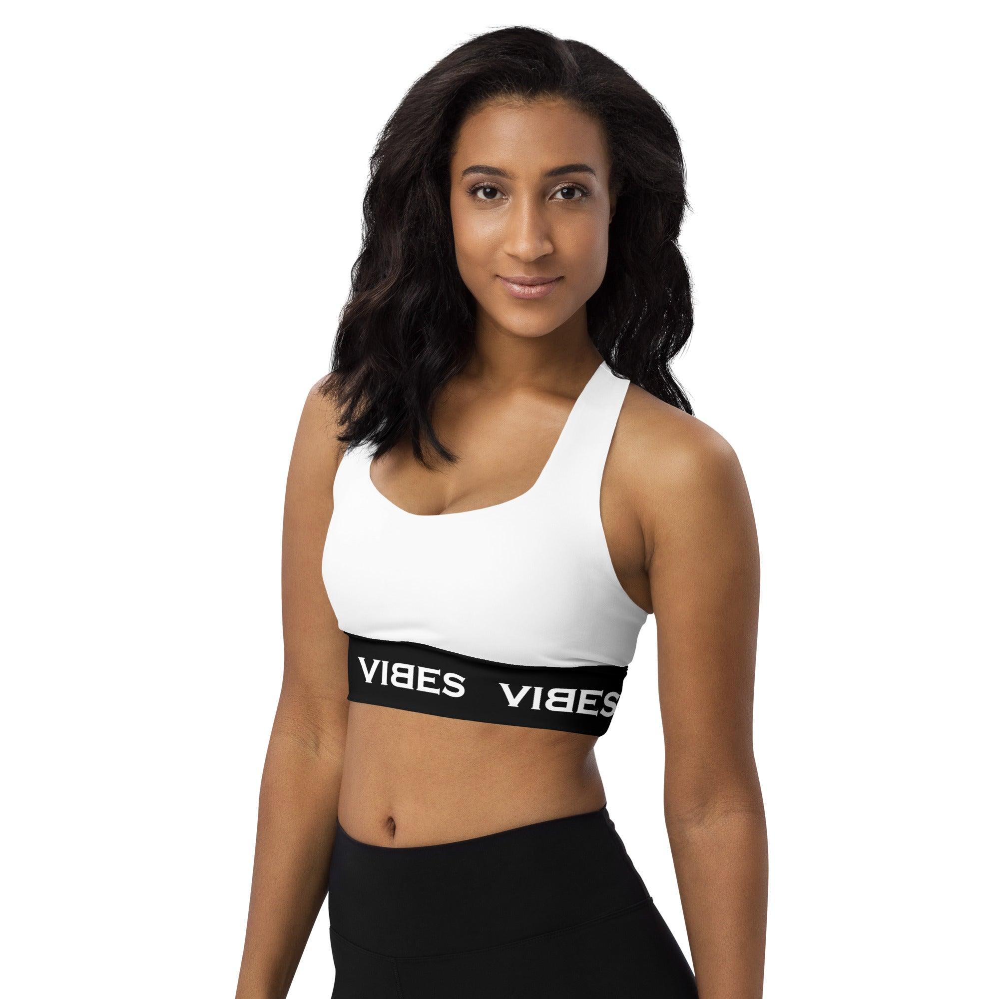Frau trägt weißen Sport-BH mit schwarzem VIBES-Logo, Studioaufnahme auf weißem Hintergrund