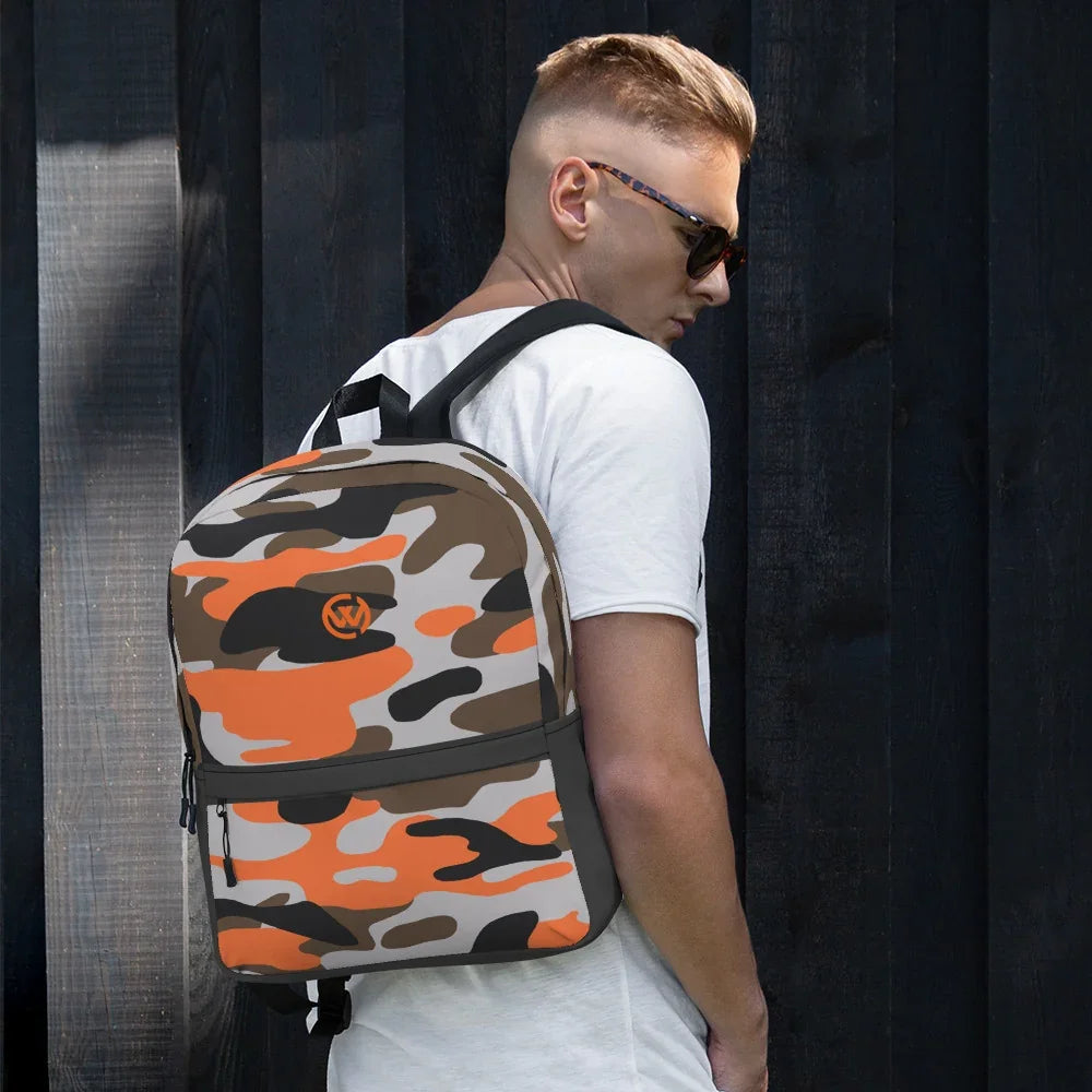 Mann mit CREWILD Rucksack im orange-braunen Camouflage-Design vor dunklem Holzhintergrund.
