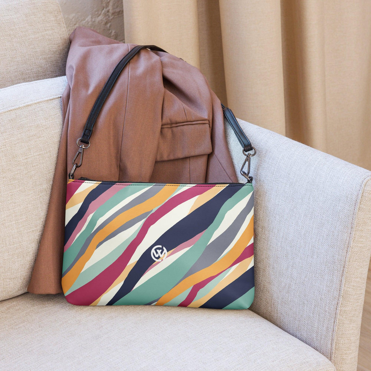 Bunte CREWILD Damen-Handtasche mit abstraktem Wellenmuster auf einem beigen Sessel
