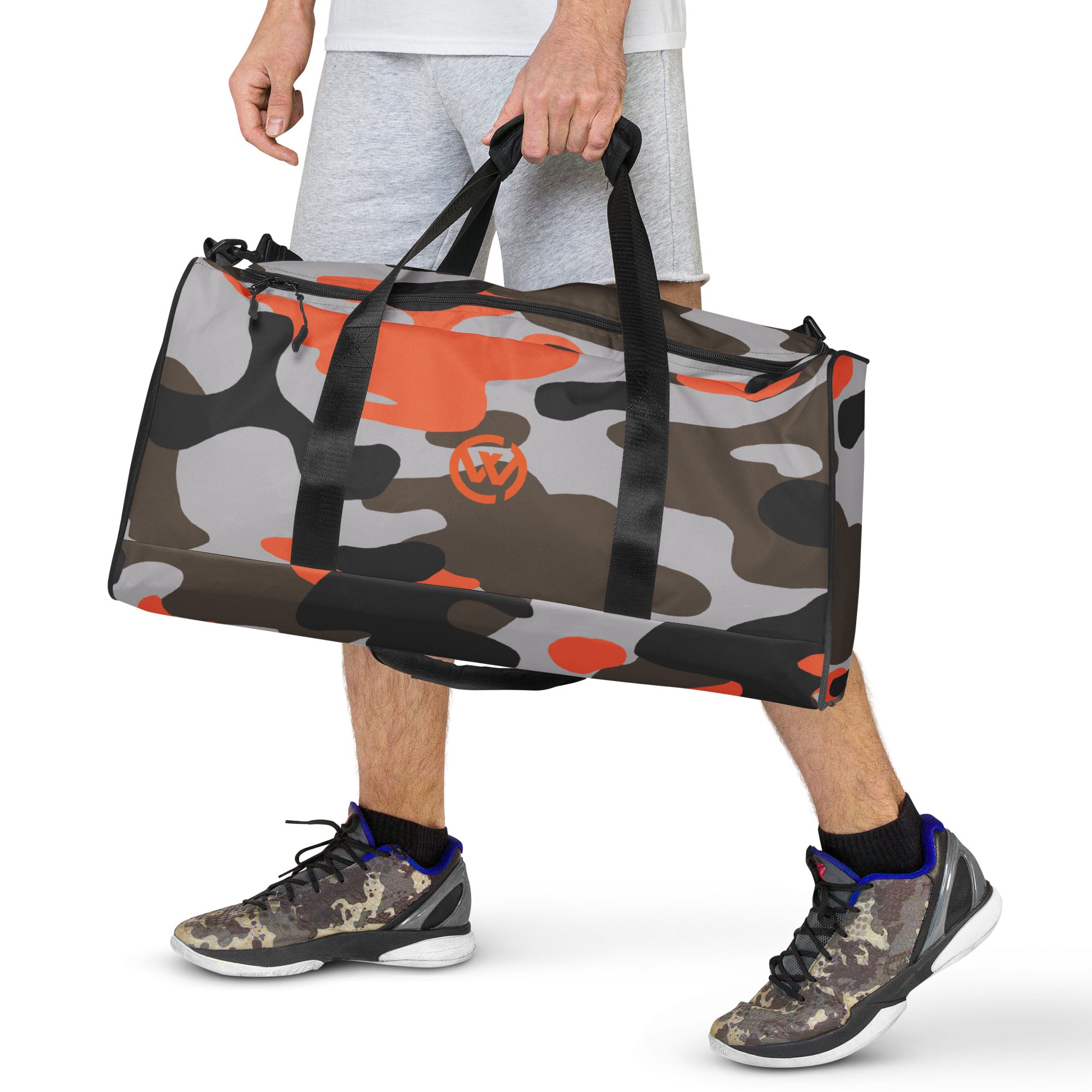 Person trägt eine personalisierte Sporttasche im Camouflage-Design mit orangefarbenen Akzenten.