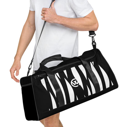 Schwarze Sporttasche mit weißem Zebramuster-Design, getragen von einer Person.