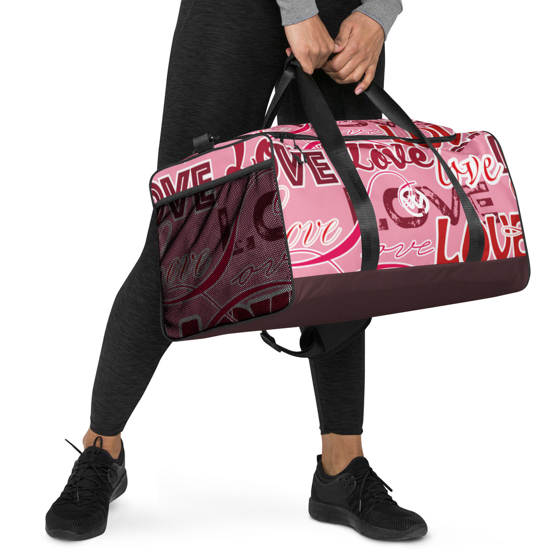 Person trägt eine pinke Sporttasche mit weißem Love-Schriftzug und schwarzem Boden.