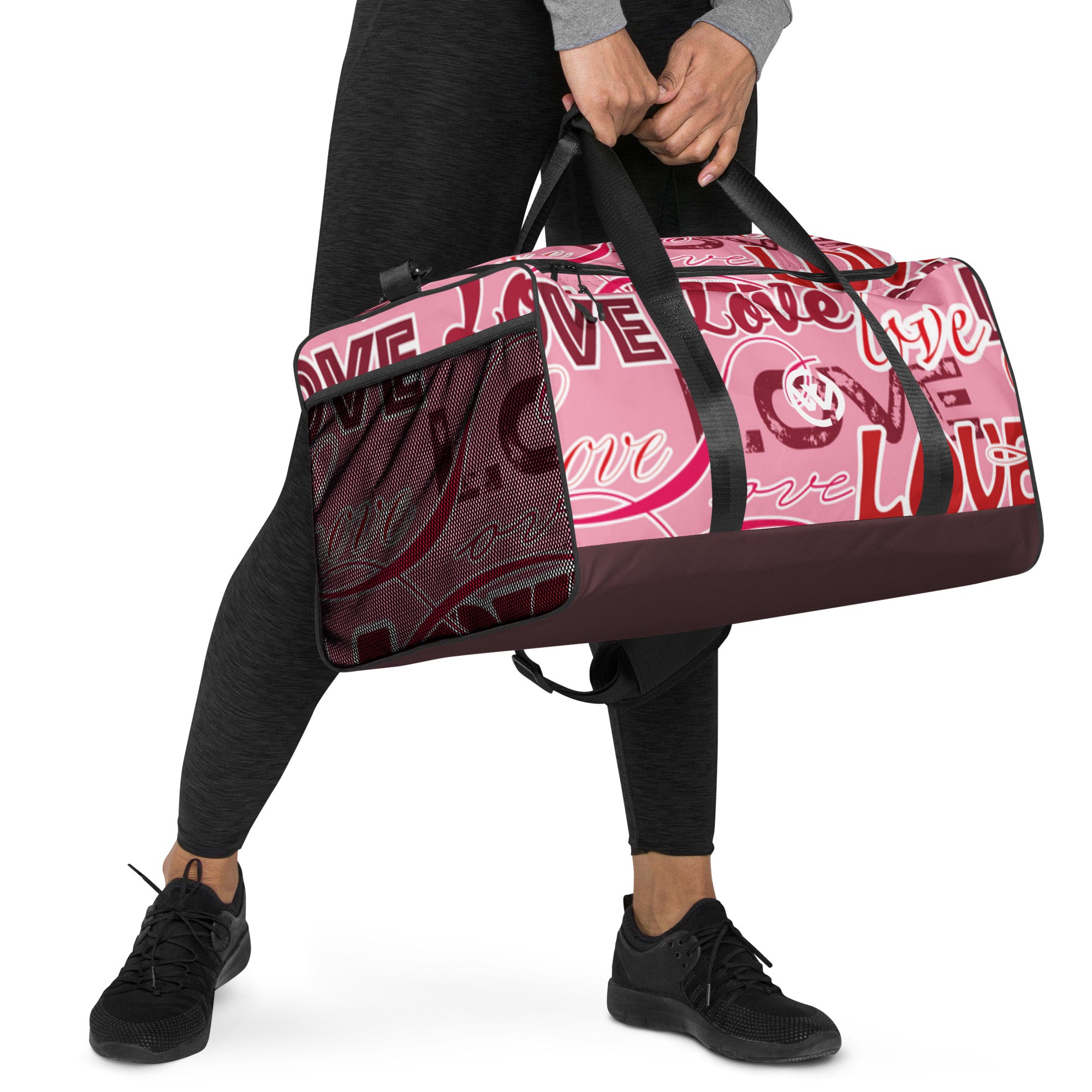 Person trägt eine pinke Sporttasche mit weißem Love-Schriftzug und schwarzem Boden.