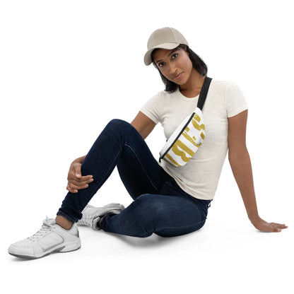 Frau in weißem T-Shirt, dunkler Jeans und weißen Sneakern mit einer gemusterten Bauchtasche.