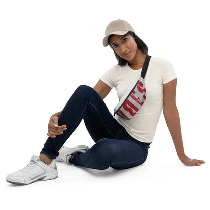 Frau in weißem T-Shirt, Jeans und weißem Sneaker mit grau-roter Gürteltasche und Cap