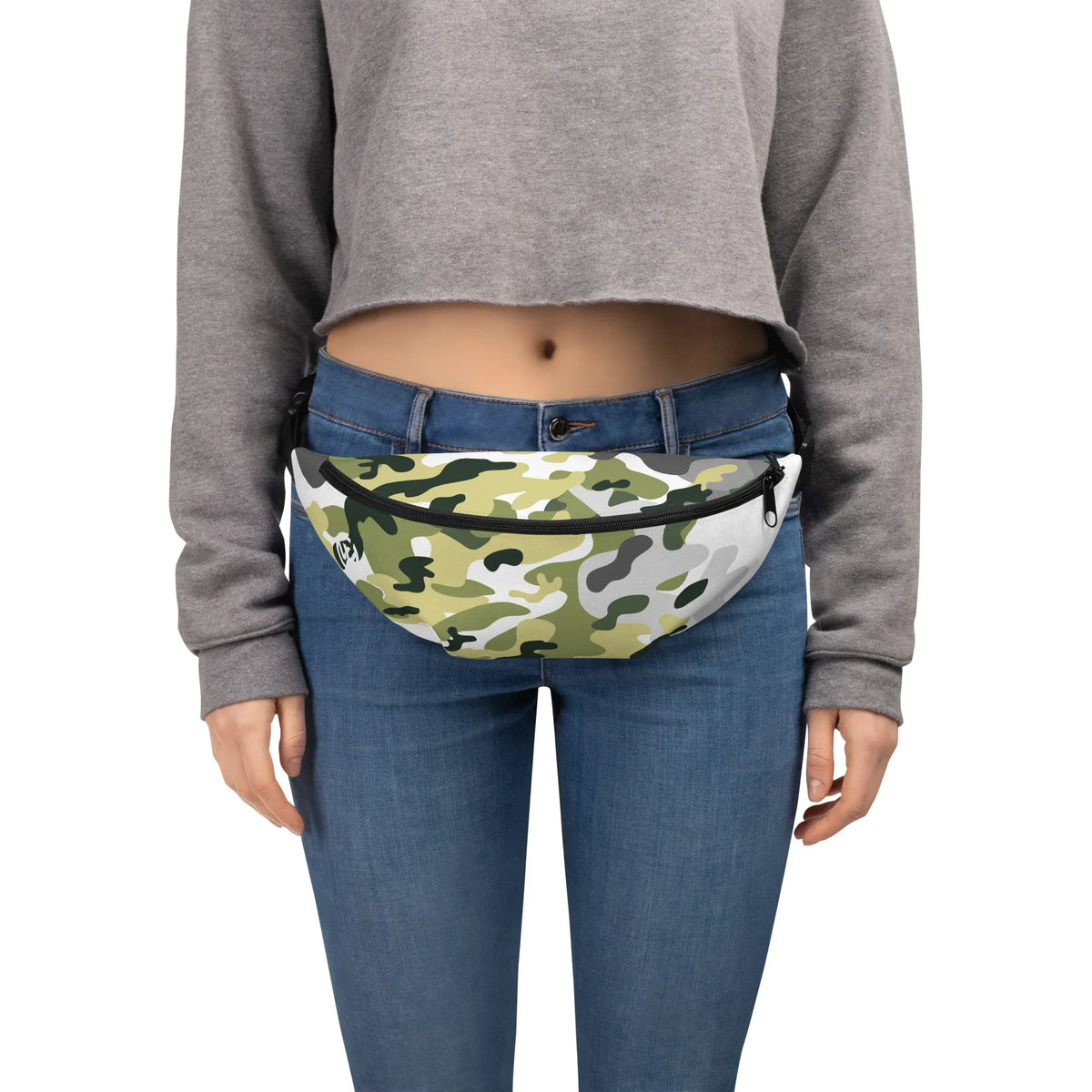 Person trägt eine Gürteltasche mit grün-weißem Camouflage-Muster zu Jeans und grauem Crop-Top.