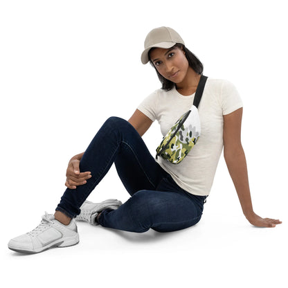 Frau mit weißem T-Shirt, dunklen Jeans, Sneakern und einer camouflagefarbenen Gürteltasche.