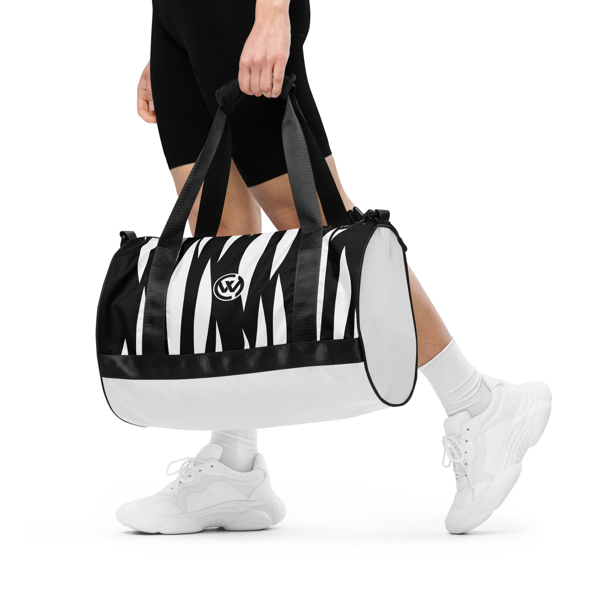 Person trägt die CREWILD Sporttasche JUNGLE in Weiß und Schwarz mit Zebra-Print.