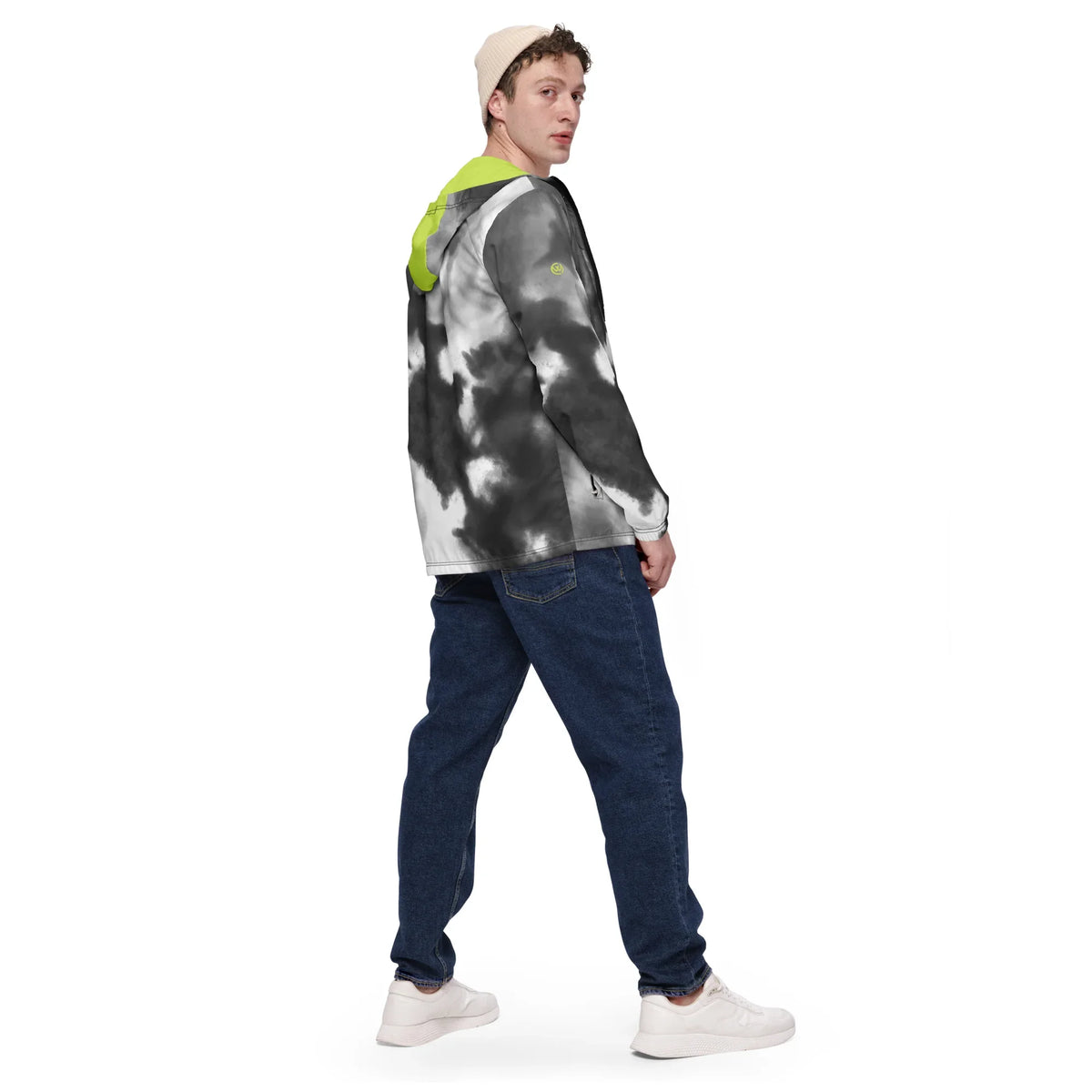 Mann in einer schwarz-weißen Tie-Dye Jacke mit neongelber Kapuze und blauer Jeans