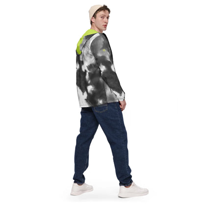 Mann in einer schwarz-weißen Tie-Dye Jacke mit neongelber Kapuze und blauer Jeans