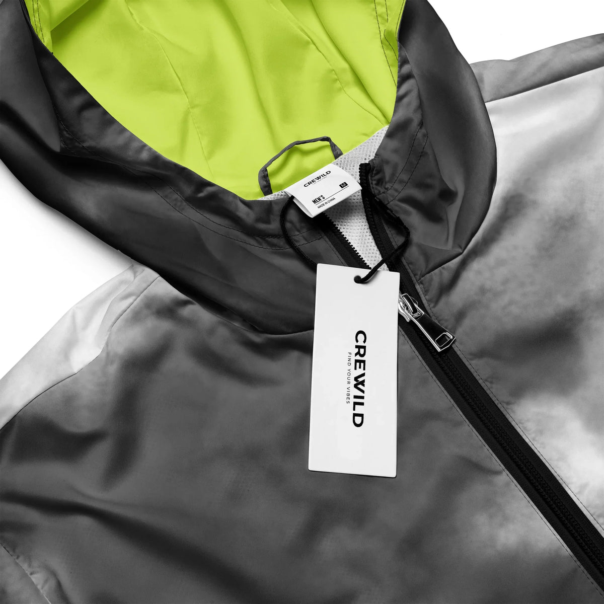 Nahaufnahme einer grauen Crewild Jacke mit neongelbem Innenfutter und Markenetikett.
