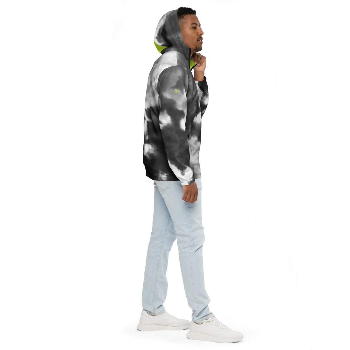 Mann in grau-weißer Tie-Dye Hoodie und hellblauen Jeans vor weißem Hintergrund