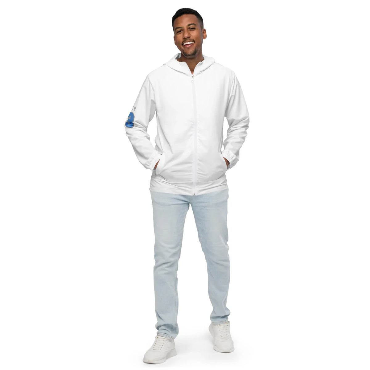 Mann in einer weißen Kapuzenjacke und hellblauen Jeans vor weißem Hintergrund