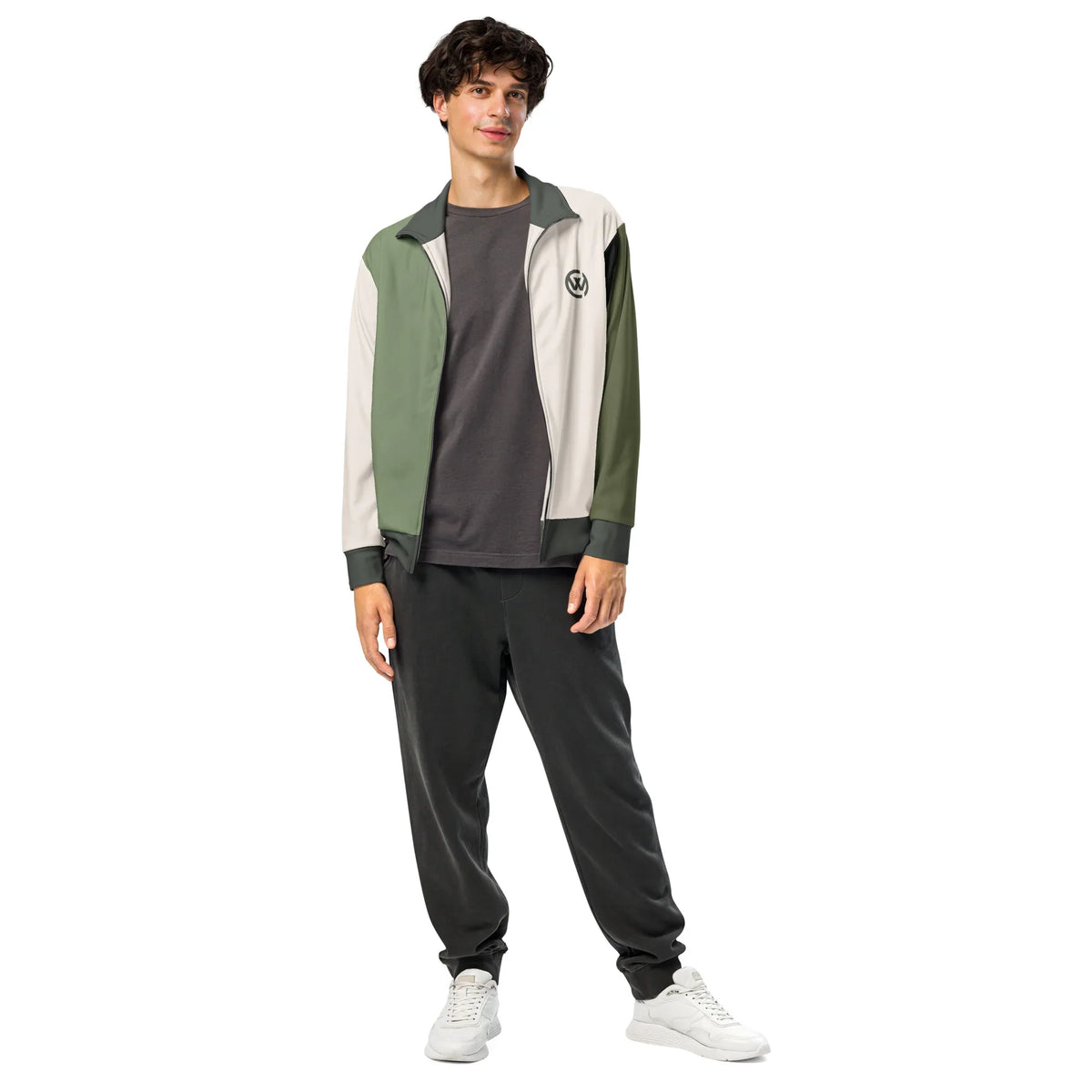Mann trägt die CREWILD Unisex Jacke in Creme und Grün mit grauen Pants und weißen Sneakern.
