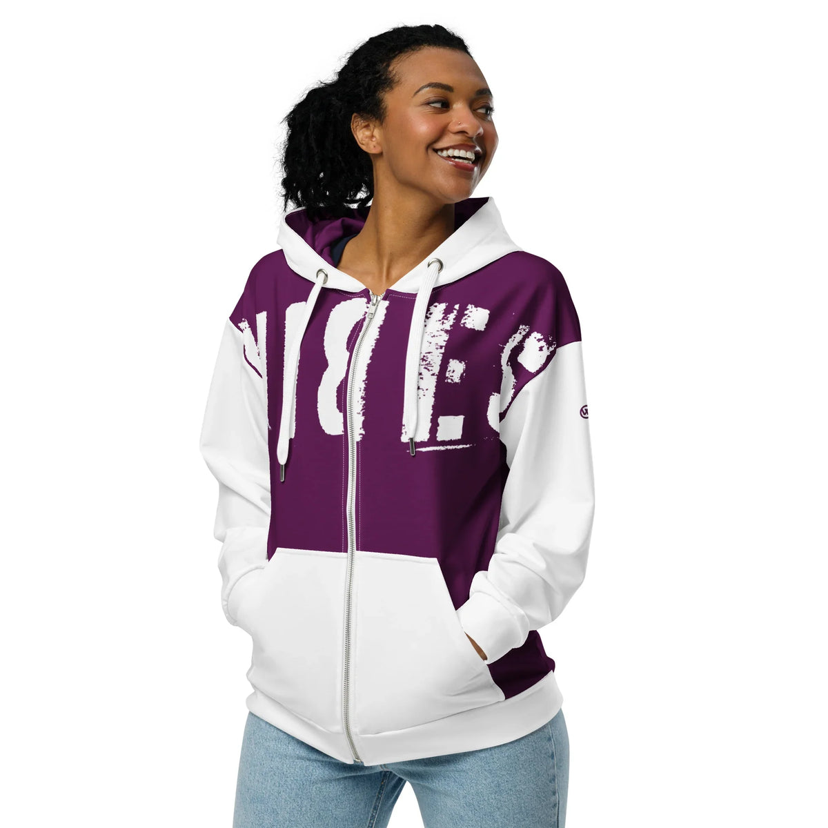 Lachende Frau in einem lila-weißen Hoodie mit großem Grafikprint.