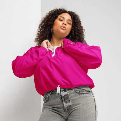 Frau mit lockigem Haar trägt eine pinke Windjacke und graue Jeans.
