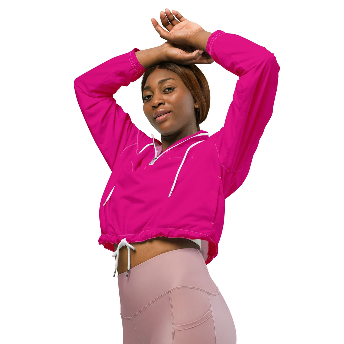 Frau in pinker, taillierter Sportjacke und hellrosa Leggings vor weißem Hintergrund