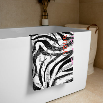 Personalisiertes Handtuch von CREWILD mit schwarz-weißem Zebra- und Ethno-Muster am Badewannenrand