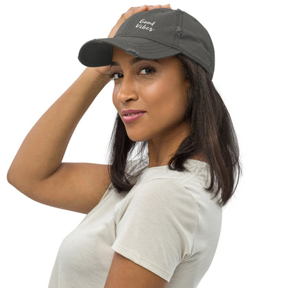 Frau trägt graue CREWILD Baseball Cap im Used-Look mit weißem Good Vibes Aufdruck.