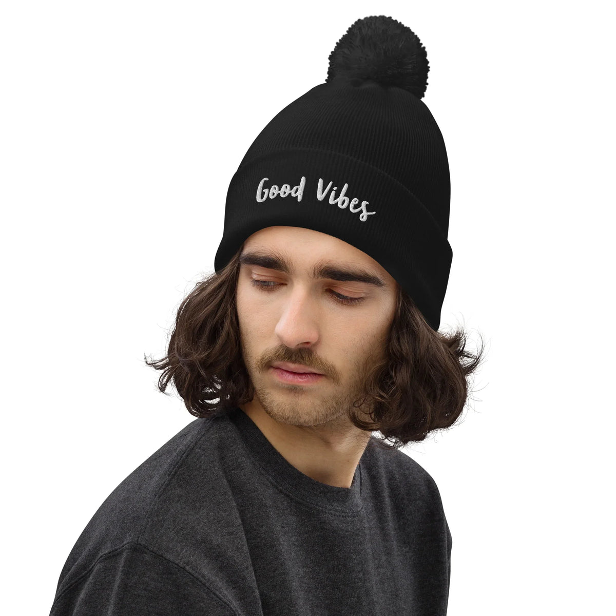 Mann mit schwarzem CREWILD Bommel-Beanie mit weißem „Good Vibes“-Schriftzug