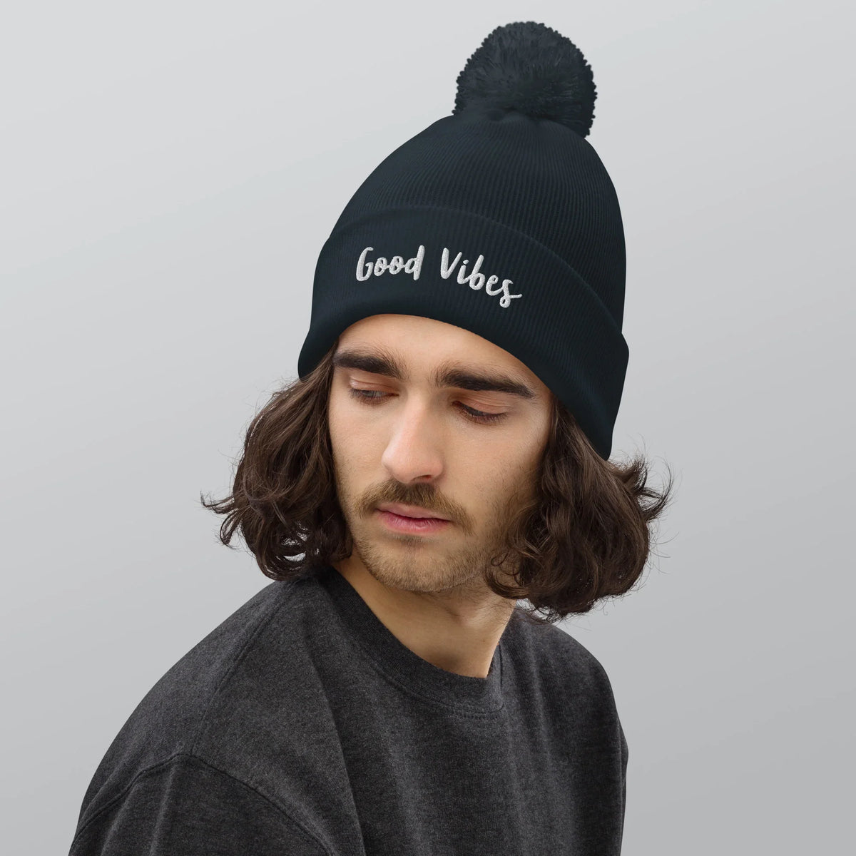 Mann mit dunkelblauem CREWILD Bommel-Beanie mit weißem &