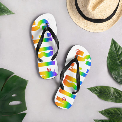 Weiße CREWILD Flip-Flops mit Regenbogen-Grafik und schwarzem Riemen auf grauem Hintergrund.