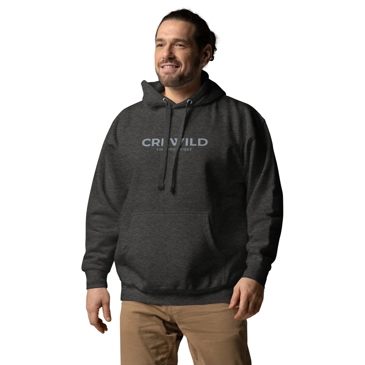 Mann in einem dunkelgrauen Hoodie mit dem Aufdruck CRNWILD und beigehosen