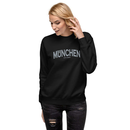 Frau trägt schwarzen unisex Sweatshirt mit Aufschrift München City Vibes, vor weißem Hintergrund