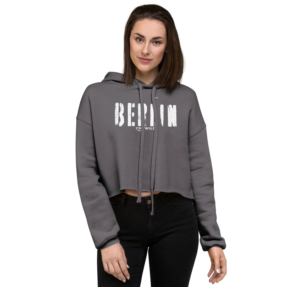 Frau in einem grauen CREWILD Crop-Hoodie mit weißem Berlin-Aufdruck und schwarzen Jeans