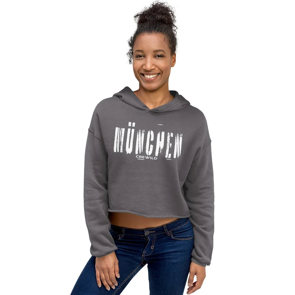 Frau trägt einen grauen CREWILD Crop-Hoodie mit weißem München-Schriftzug.