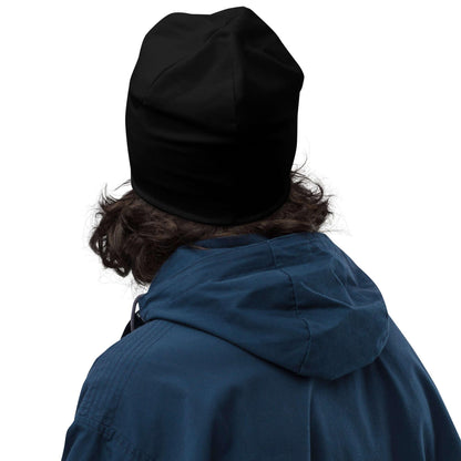 Person mit schwarzer Beanie und blauer Jacke vor weißem Hintergrund