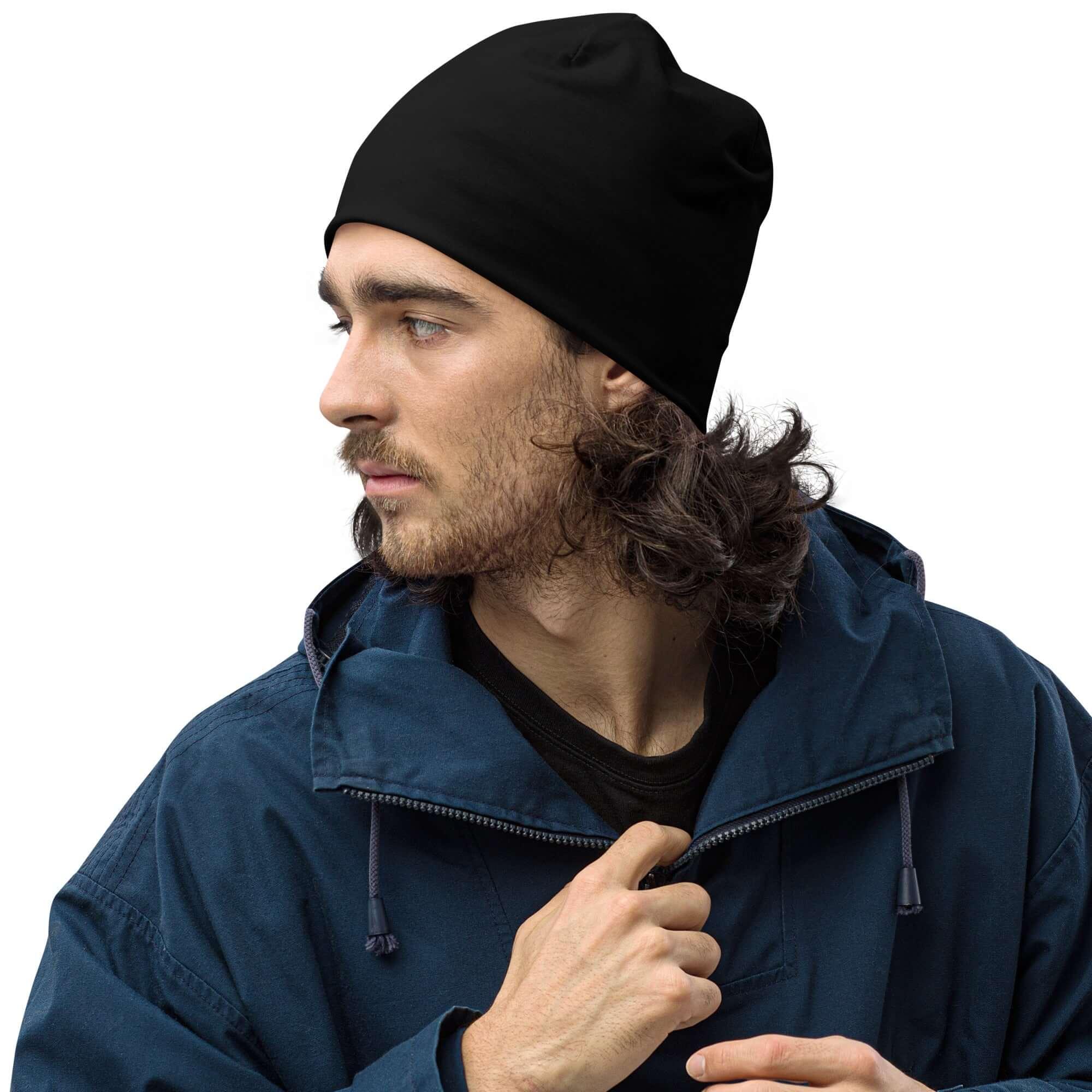 Mann mit schwarzer Beanie-Mütze und blauer Jacke, seitliches Porträt, weißer Hintergrund