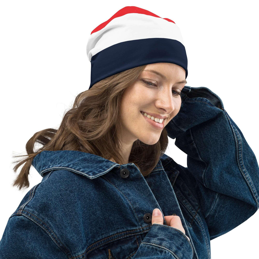 Frau mit dreifarbiger Beanie-Mütze in Rot, Weiß und Dunkelblau, Jeansjacke, weißer Hintergrund