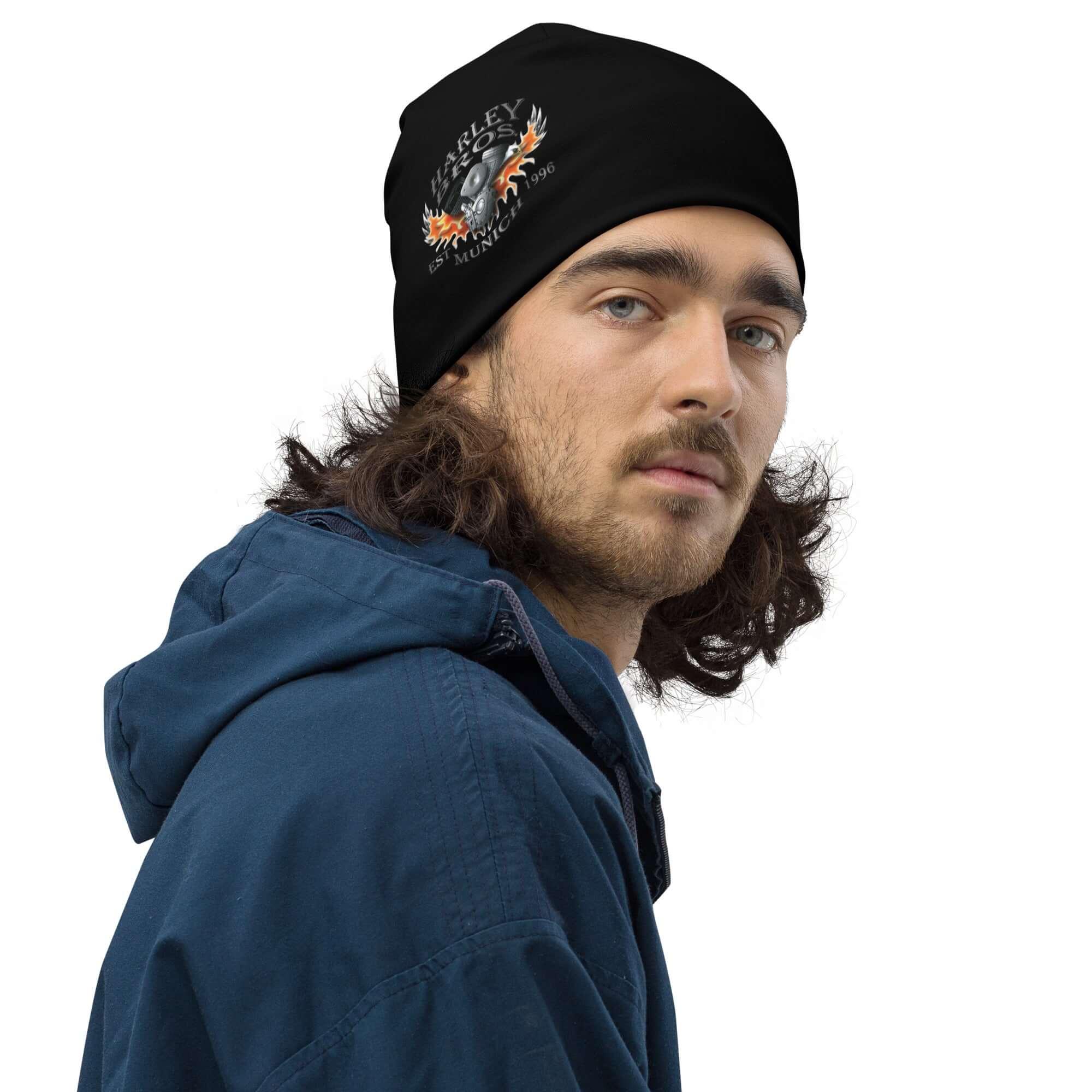 Mann mit schwarzer Harley-Beanie, Flammen-Schädel-Motiv, blauer Kapuzenjacke, weißer Hintergrund